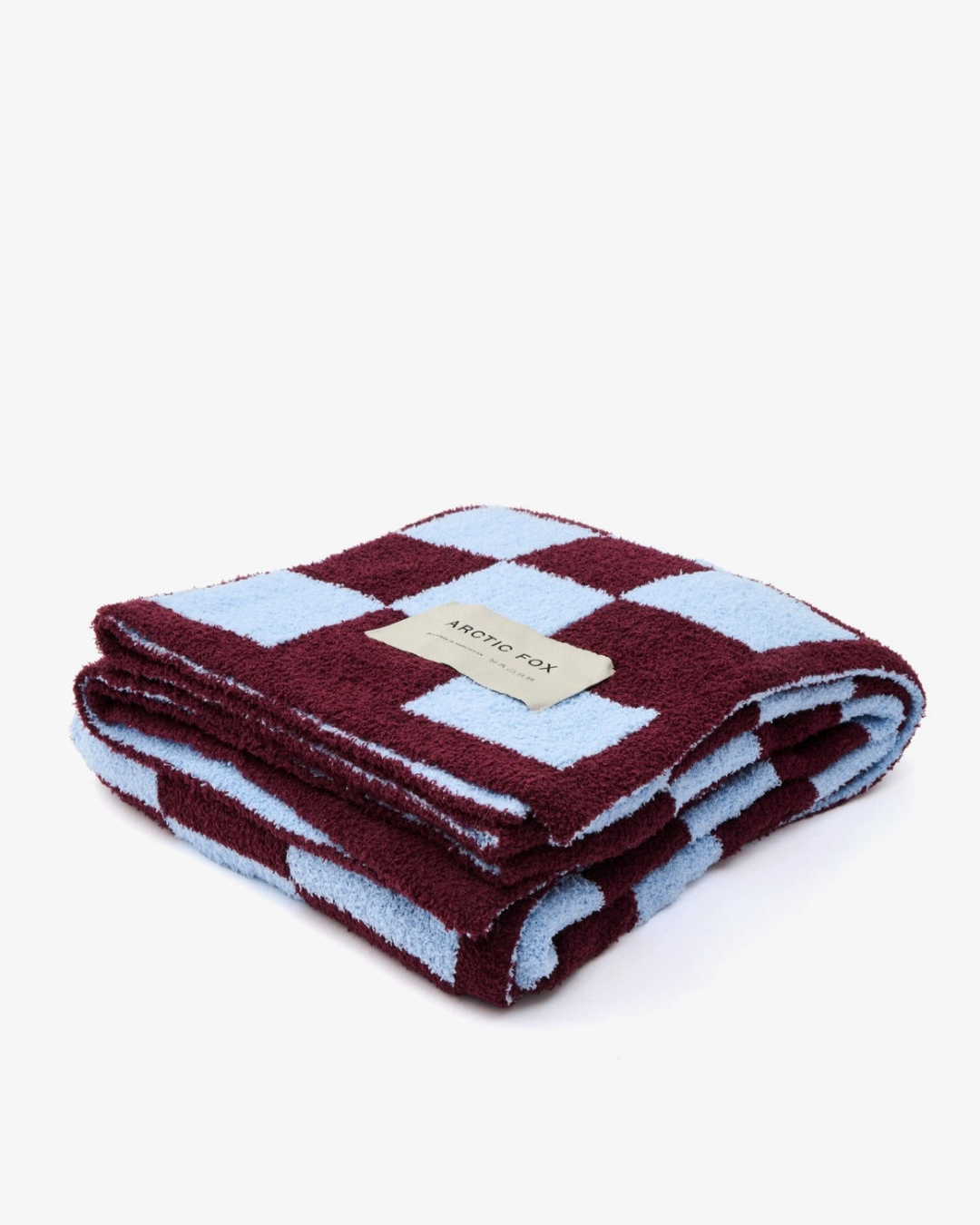 Folded checkered blanket with a brand label on a white background
