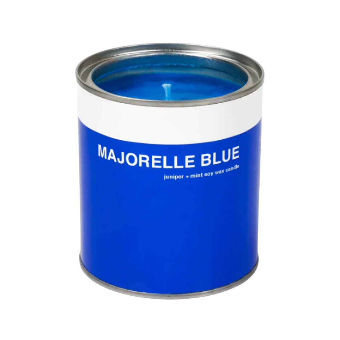 A blue candle container that looks like a miniature paint can, labeled 'MAJORELLE BLUE' with a lid.