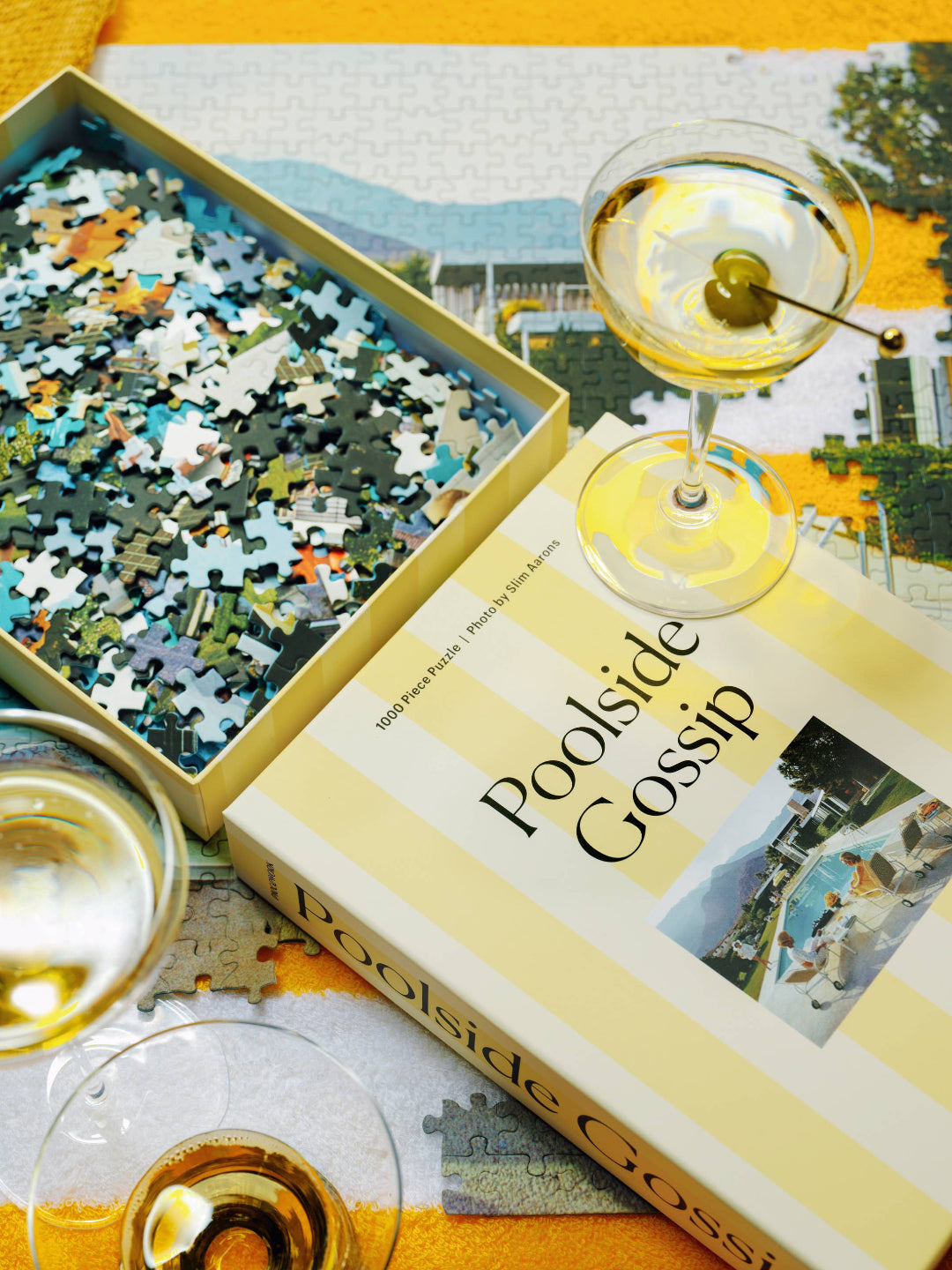 'Poolside Gossip' puzzle box with a martini on a yellow surface