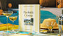'Poolside Gossip' puzzle box on a poolside table with drinks and decor.
