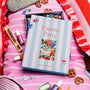 Pajama Party puzzle box on a pink striped pillow with decorative items